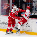 20240117 Ässät vs. Sport, Liiga runkosarja, Pori. Kuvassa 6 Jesse Joensuu taklaa 16 Theodor Johnsson, taustalla nuori ässäkannattaja Joensuun pahvipään kanssa. Elmeri Elo / Apollo Photo